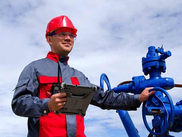 An oil worker uses a rugged tablet