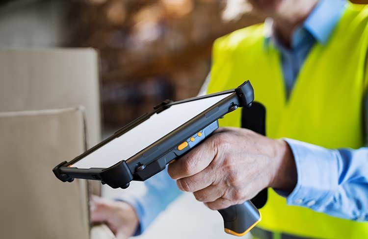 A worker uses a barcode scanner with a tablet