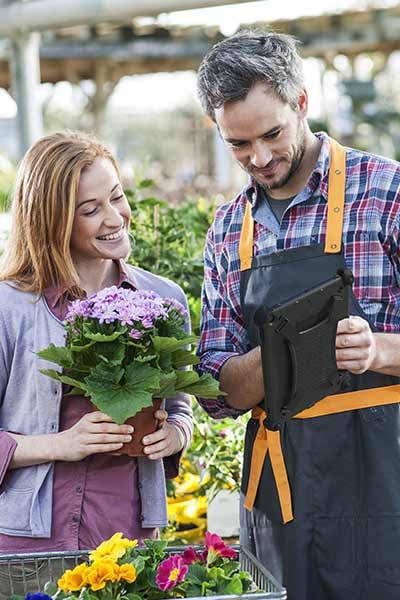 A couple uses a tablet in a garden center