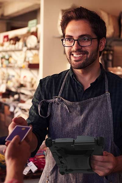 A man accepts a credit card holding a rugged tablet with magstripe