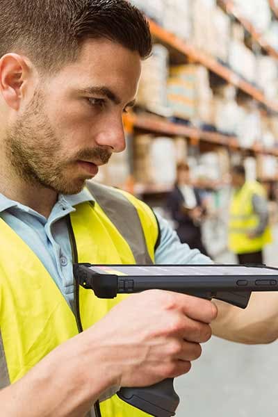 A man uses a scanner in a warehouse
