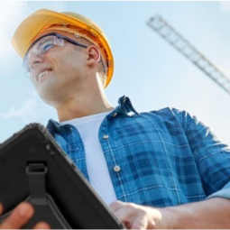 construction worker holding rugged tablet wearing hardhat