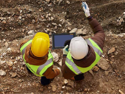 Top down view of two construction workers holding rugged tablet