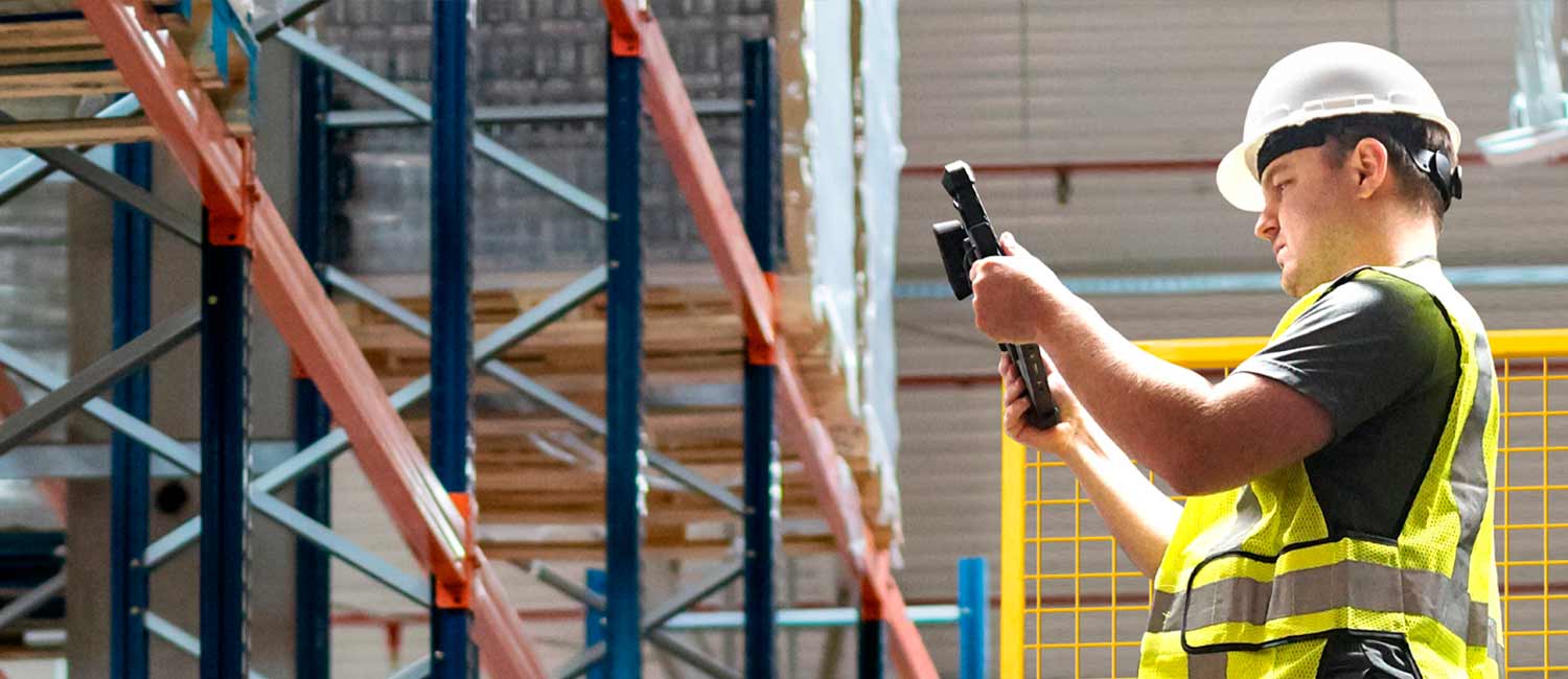 A worker scans items on a lift in a warehouse