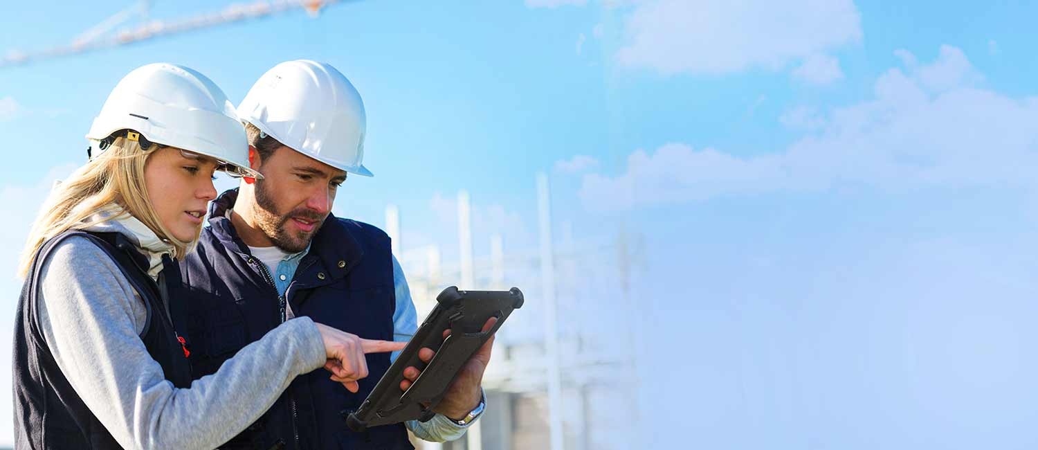 Two construction workers use a rugged tablet