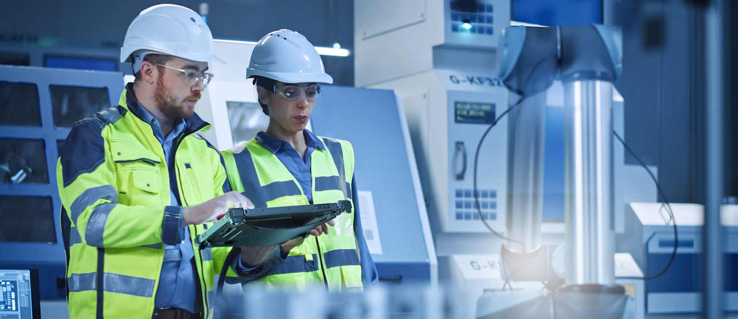 Two workers use a rugged tablet in a lab