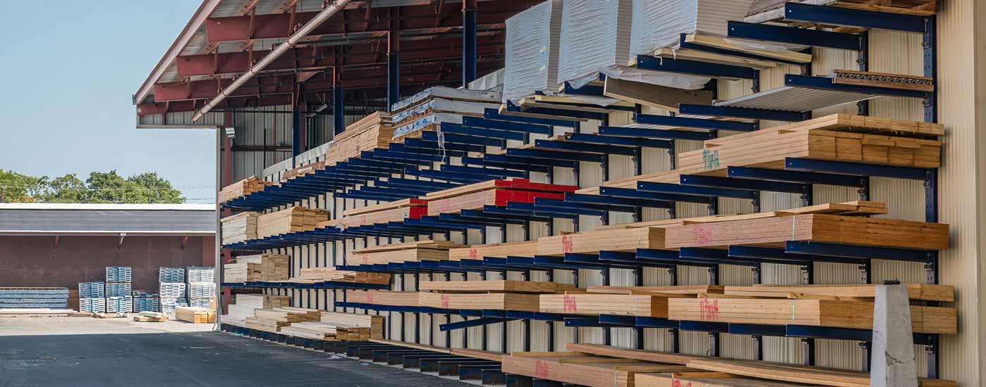 Stacks of lumber being stored in a at a lumber yard.