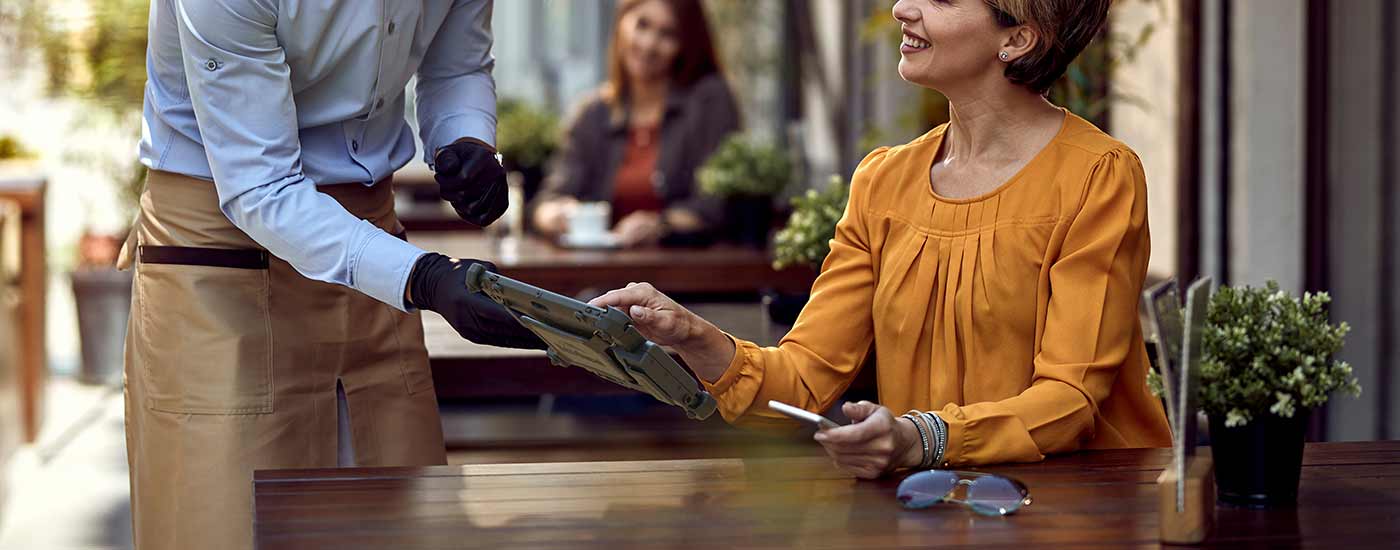 A server uses a Rugged Tablet to accept payment at a restaurant