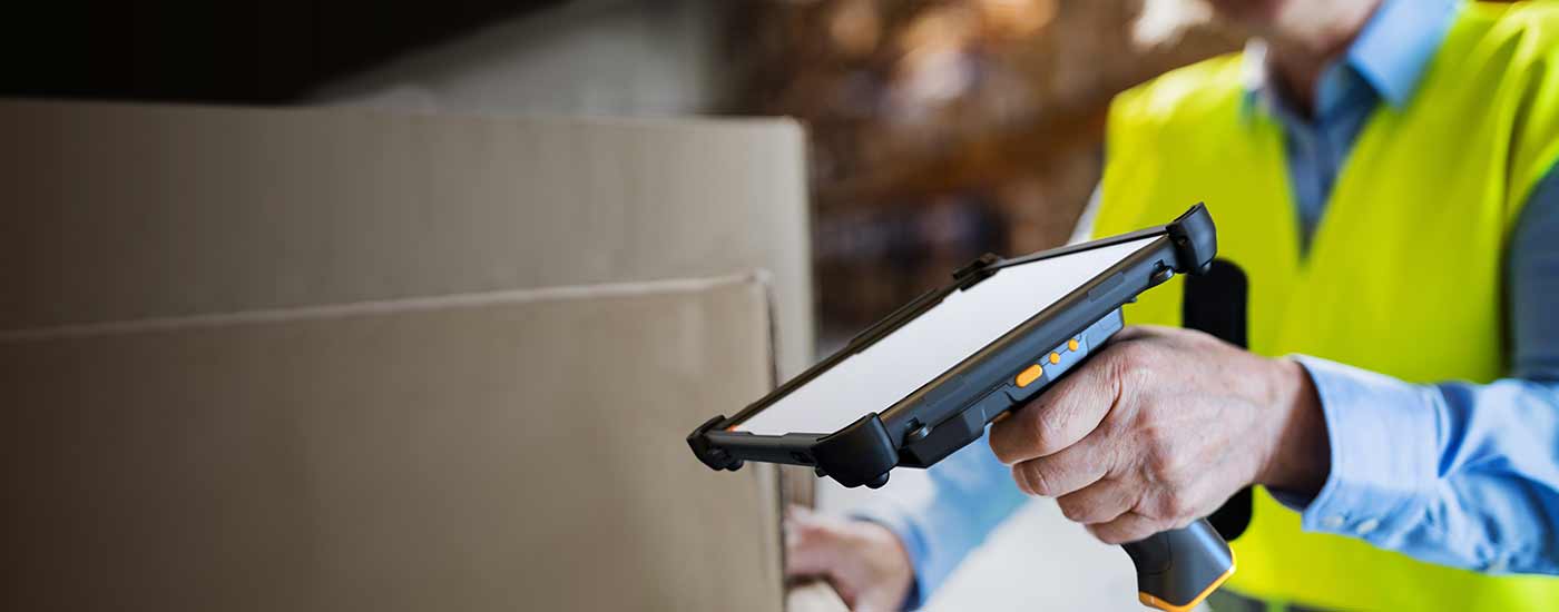 A worker in a warehouse scans with a handheld scanner