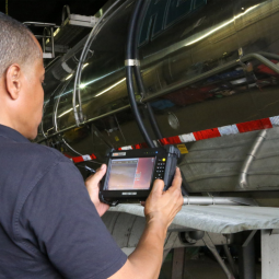 Man holding a rugged tablet in front of truck