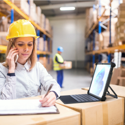 female warehouse worker using rugged tablet with keyboard