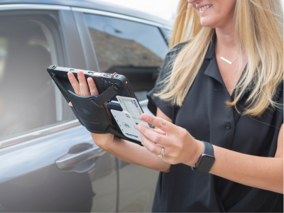 female worker holding rugged tablet with integrated payment device swiping credit card