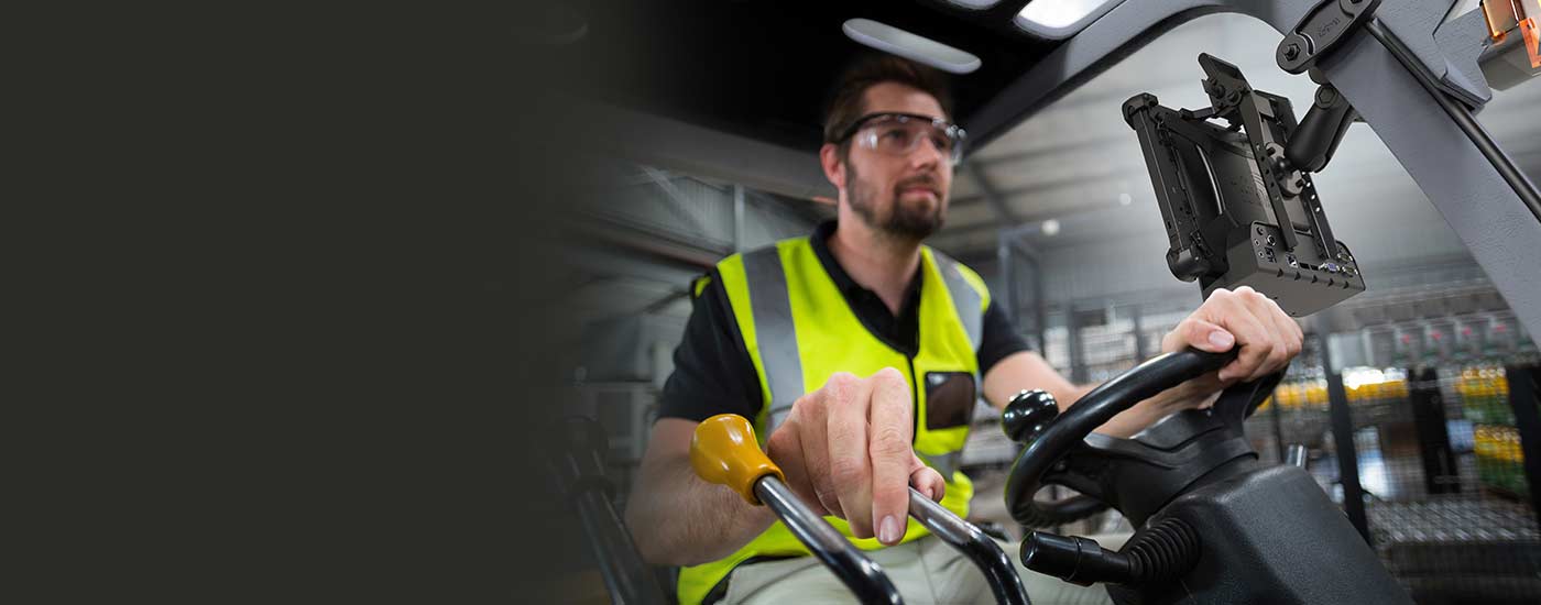 A worker operates a forklift with a Rugged Tablet attached