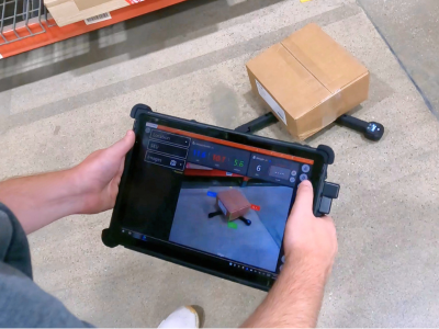 man holding rugged tablet with xdim software to dimension cardboard box